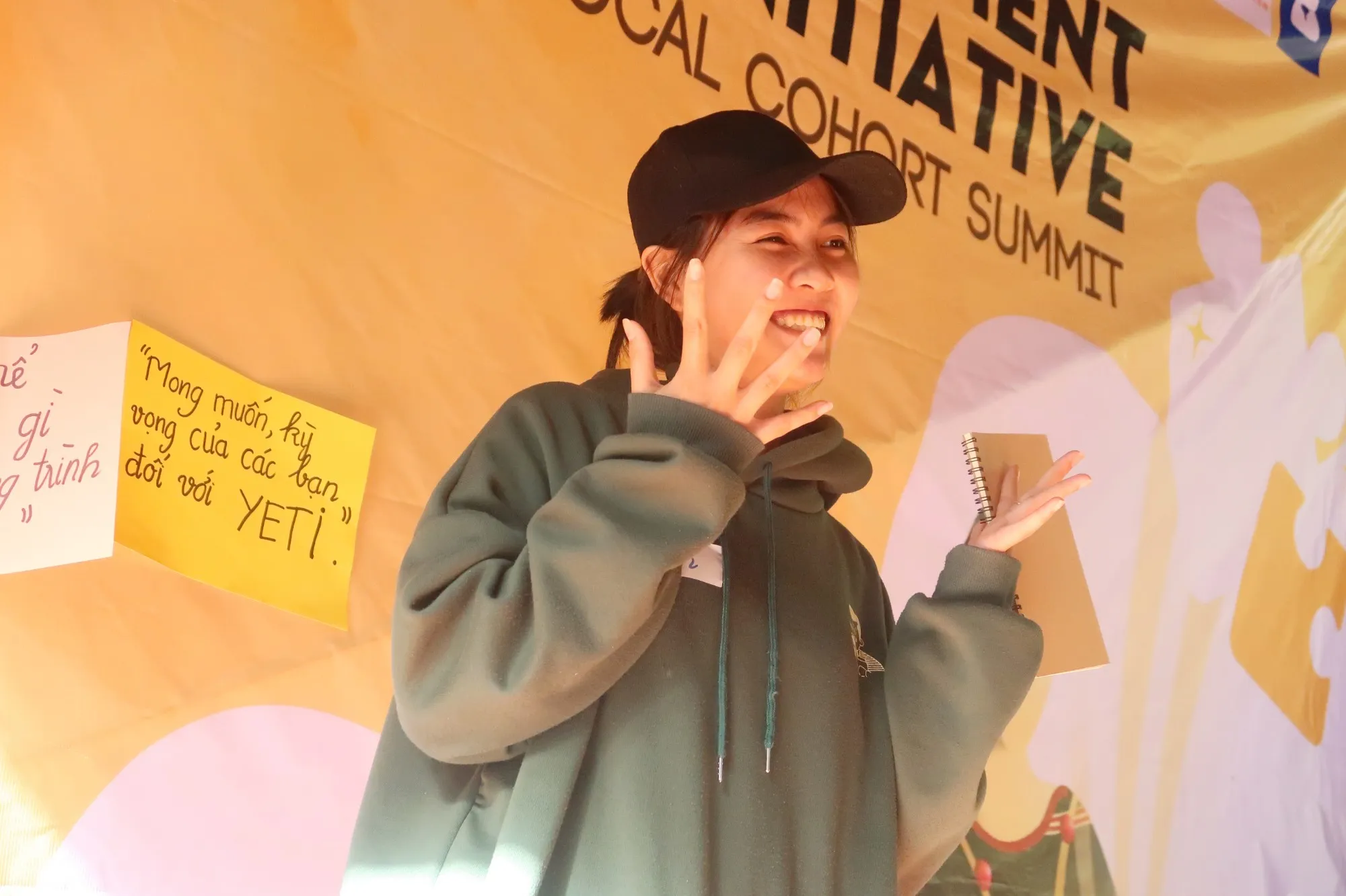 A YETI participant laughing and waving at The Local Cohort Summit