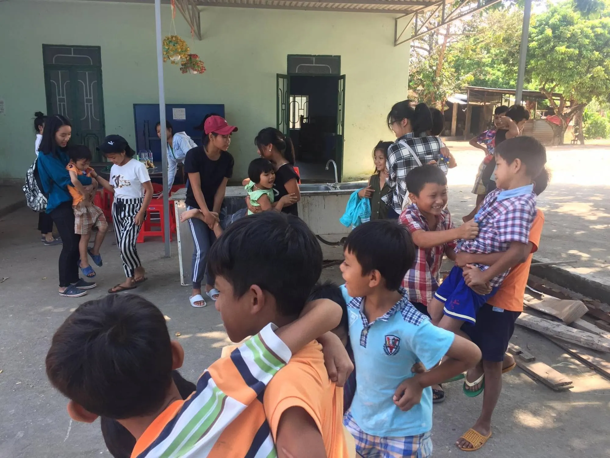 Volunteers and children playing together in the yard at Vinh Sơn 5