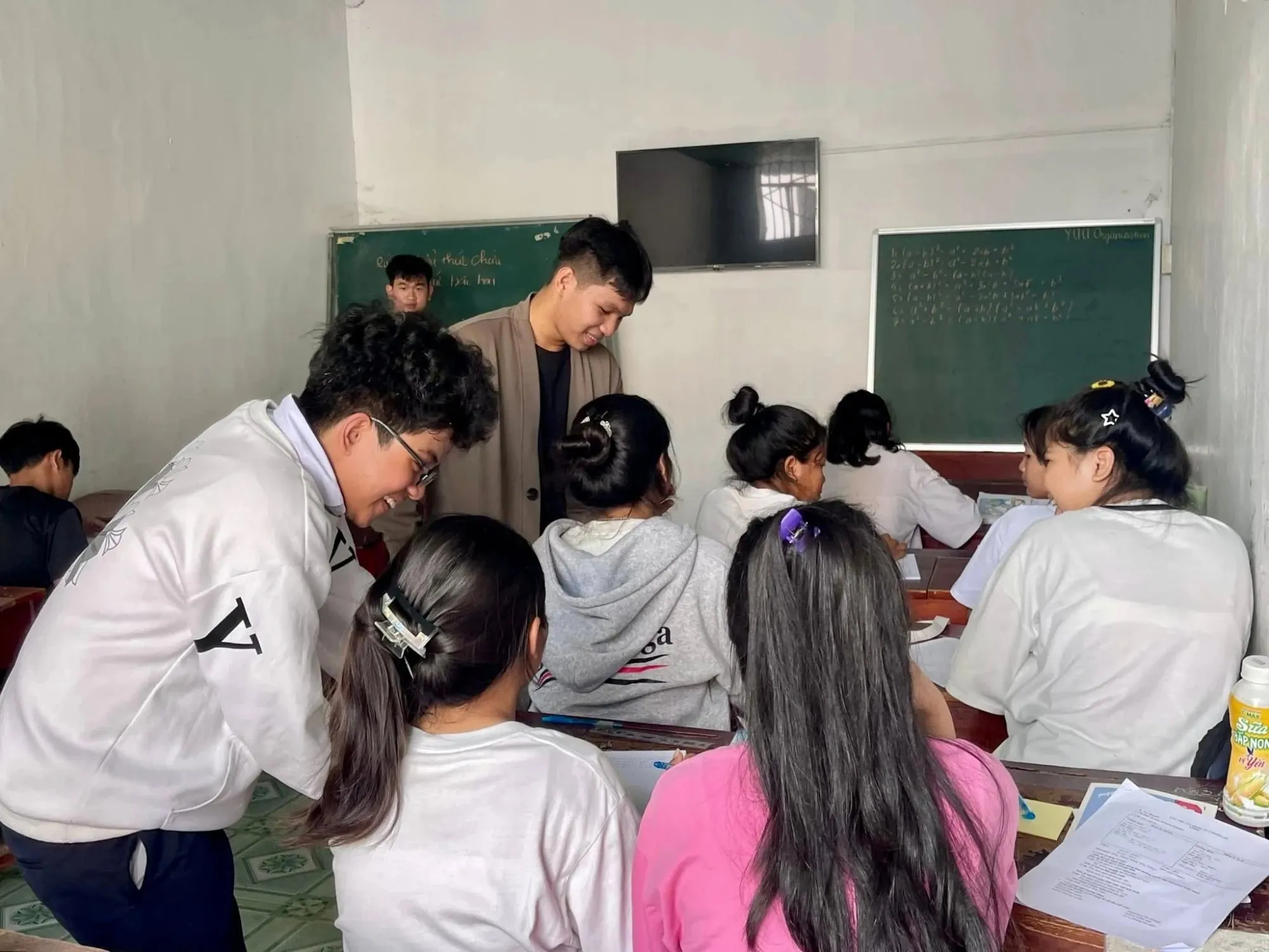 Volunteers helping students with their work in a classroom