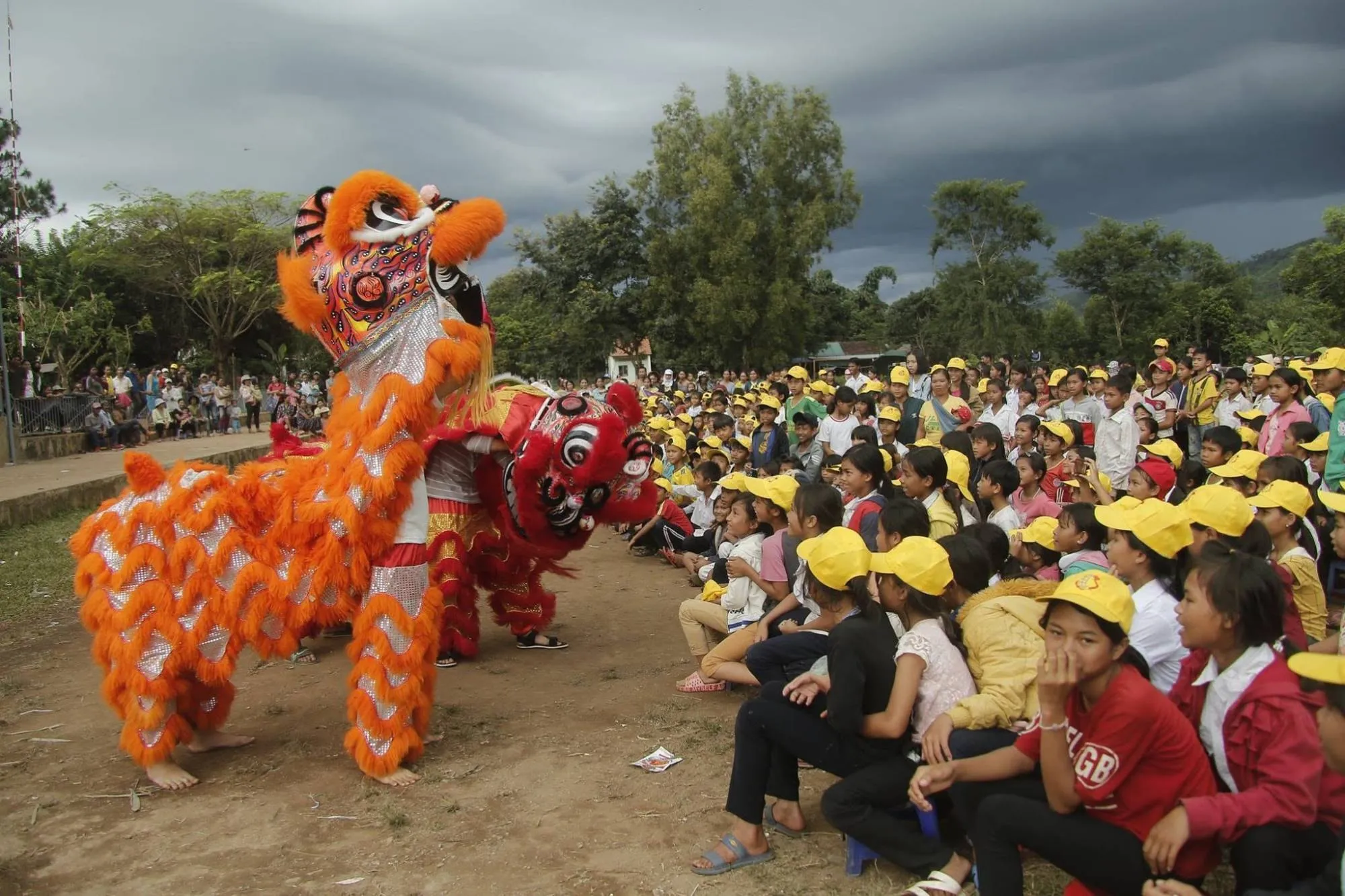 Children in yellow caps watching a lion dance at the Mid-Autumn Festival