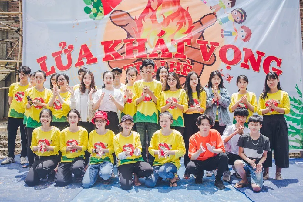 The YETI team in yellow camp shirts in front of the Lửa Khát Vọng banner